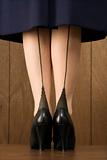 Close-up shot of woman in skirt with black heels. 