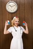 Female nurse in retro uniform holding giant pills. 