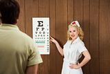 Female nurse pointing out eye chart to man.