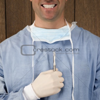 Male surgeon holding scalpel.