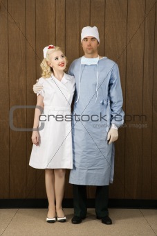 Female nurse and male surgeon standing together.