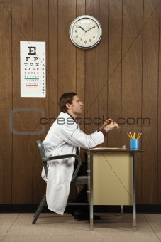 Side view of male doctor at desk.