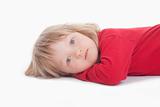 boy with long blond hair lying down, looking at camera - isolated on white