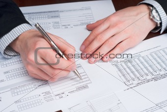 Business men signing documents on a desk.