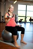 Pregnant woman exercising with weights
