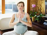 pregnant woman doing yoga at home