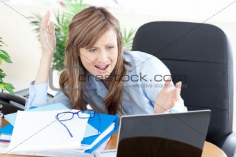 Angry businesswoman looking at the laptop 