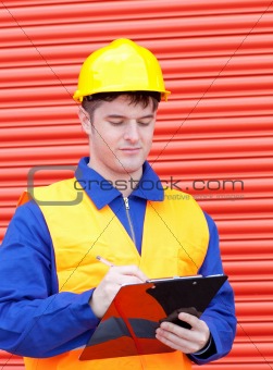 Serious male engineer writing his report 