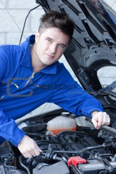 Professional man repairing a car in a garage