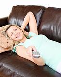 Relaxed woman using a remote 