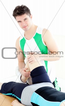 Young male physical therapist checking a woman's knee 