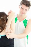 Smiling physical therapist checking a woman's shoulder 