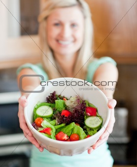 Happy woman showing a salad 