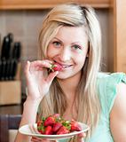 Delighted woman eating fruits
