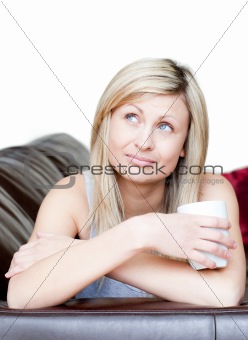 Pensive woman holding a cup of coffee 