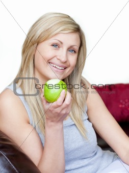 Joyful woman eating an apple