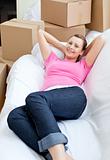 Beautiful woman relaxing on a sofa with boxes