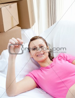 Portrait of a beautiful woman relaxing on a sofa with boxes at home