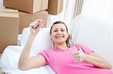 Positive woman relaxing on a sofa with boxes