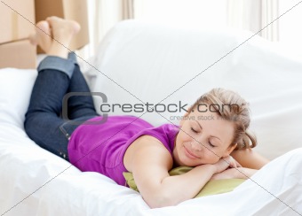 Portrait of a cheerful woman relaxing on a sofa with boxes 