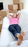 Cute woman relaxing on a sofa with boxes