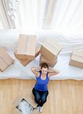 Tired woman sitting between boxes 