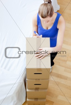 Caucasian woman is moving various boxes 