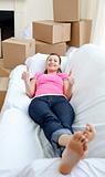 Attractive woman relaxing on a sofa with boxes