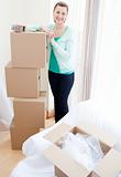 Attractive woman closing a box at home