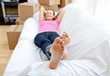 Portrait of a beautiful woman relaxing on a sofa with boxes at home