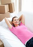 Delighted woman relaxing on a sofa with boxes