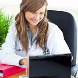 Bright female doctor working with a laptop 