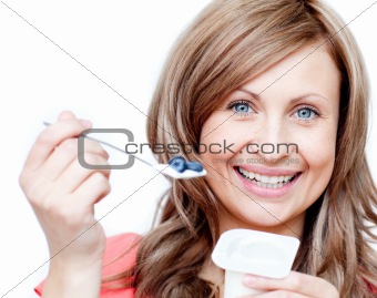 Smiling woman eating a yogurt 
