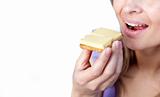 Close-up of a woman eating a cracker with cheese 