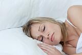 Blond woman sleeping in a bed