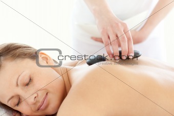 Portrait of a radiant woman having a massage with stones 