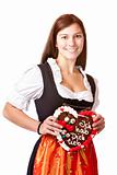 woman in love wearing Dirndl cloth holds gingerbread heart