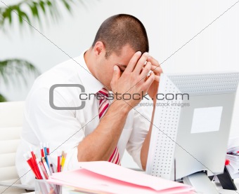 Frustrated businessman working at a computer 