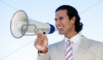 Portrait of a latin business man shouting through a megaphone