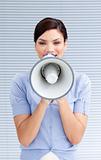 Positive businesswoman yelling through a megaphone 