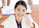 Confident businesswoman with thumbs up