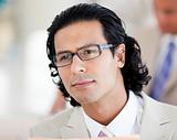 Young businessman looking to the camera wearing glasses