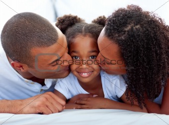 Loving parents kissing their daughter