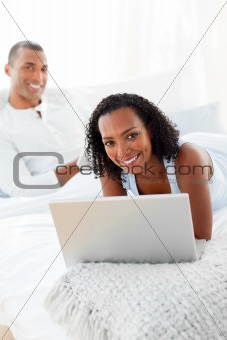Cheerful couple relaxing on their bed 