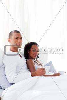 Loving couple drinking a coffee on their bed