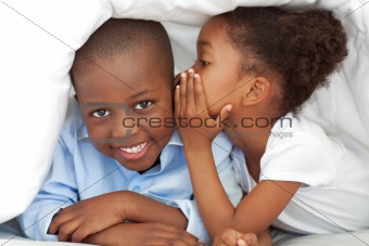 Cute little girl whispering something to her brother