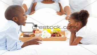 Happy family having breakfast in the bedroom