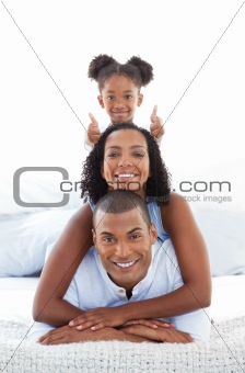Portrait of a attentive parents with their children playing on a bed