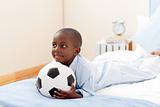 Happy little boy holding a soccer ball 