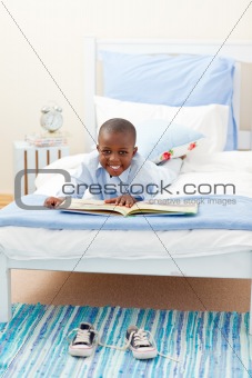Smiling little boy reading a book